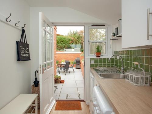 a kitchen with a sink and a table with chairs at Haldon View in Lympstone