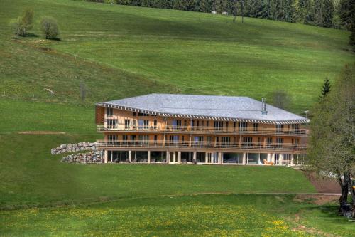 a large building in the middle of a field at derWaldfrieden naturparkhotel in Herrenschwand