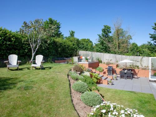 a garden with two chairs and a table and a patio at Haldon View in Lympstone
