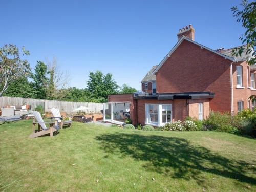 a yard with two chairs and a brick house at Haldon View in Lympstone