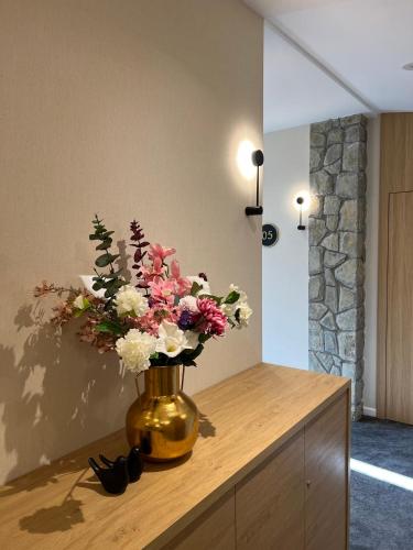a vase filled with flowers on top of a table at Hotel Aria in Podgorica