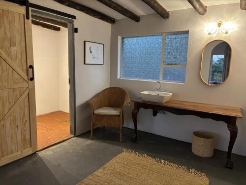 a bathroom with a sink and a mirror and a chair at Bateleur Nature Reserve in Modimolle