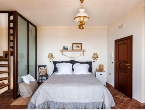 a bedroom with a large bed and a chandelier at VitaLenta in Naxos in Giardini Naxos