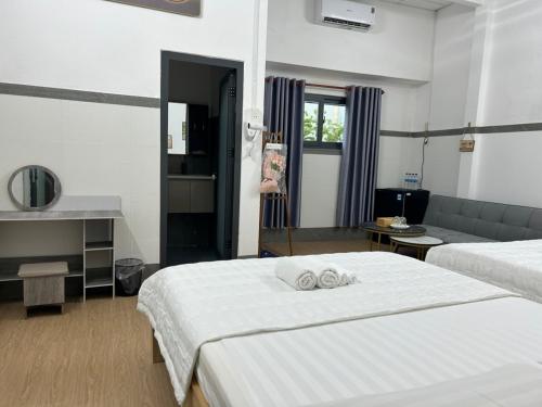 a hotel room with two beds and a couch at Hotel Hồng Cẩm in Trung An