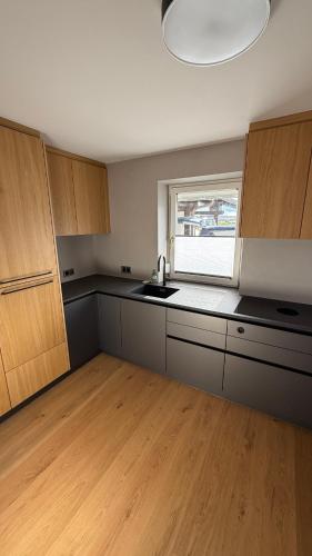 an empty kitchen with a sink and a window at Villa Wie II in Niedernsill