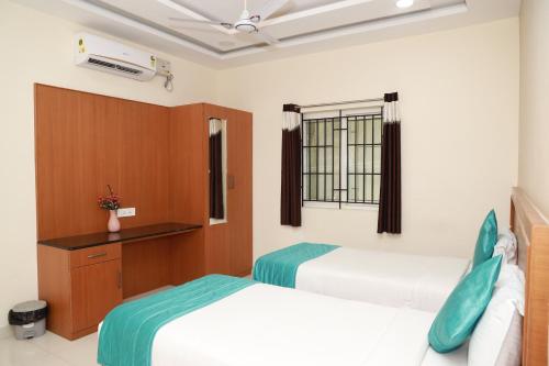 a hotel room with two beds and a window at Kanmani Elite- A Perfect Home in Tiruchchirāppalli
