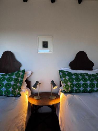 a room with two beds and a table with two lamps at Bateleur Nature Reserve in Modimolle