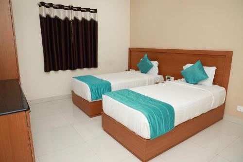 two beds in a room with a television at Kanmani Elite- A Perfect Home in Tiruchchirāppalli