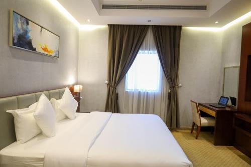 a hotel room with a bed and a desk and a window at Best Day Hotel and Resorts المحمدية in Jeddah