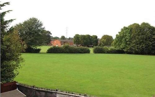 a large green field with a house in the background at Shared Double Rooms in Buckinghamshire