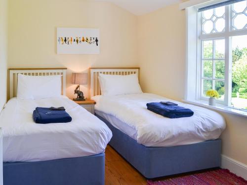 two beds sitting next to each other in a bedroom at The Dower House in Stowbridge