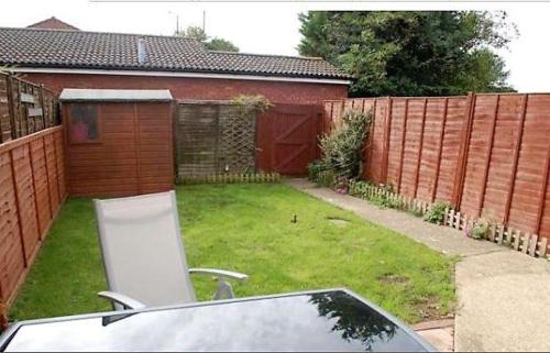 a backyard with a fence and a chair in the yard at Shared Double Rooms in Buckinghamshire