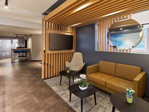 a living room with a couch and a tv at B&B Hotel Köln-Airport in Cologne