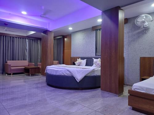 a bedroom with a large bed with purple lighting at Hotel Heritage Inn in Mehsāna