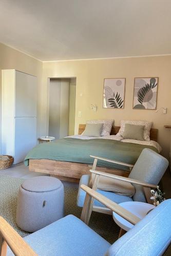 a bedroom with a large bed and some chairs at Ferienwohnung Zeitwinkel in Reil