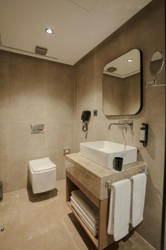 a bathroom with a sink and a toilet and a mirror at NearYo Hotels in Marrakech