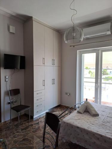 a bedroom with a bed and a tv and a window at Sofia's apartment in Karistos