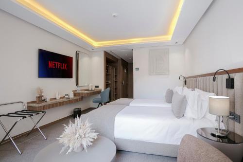 a hotel room with a large white bed and a desk at NearYo Hotels in Marrakech