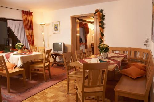 Un comedor con mesas y sillas y un televisor. en Ferienhaus Für 11 Personen Und 1 Kind, en Birresborn