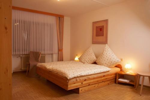 Un dormitorio con una cama con dos lámparas y una ventana. en Ferienhaus Für 11 Personen Und 1 Kind, en Birresborn