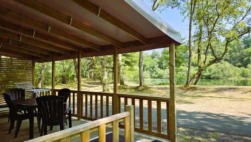 a screened porch with a table and chairs on it at Camping L'Etang D'Ardy *** in Saint-Paul-lès-Dax