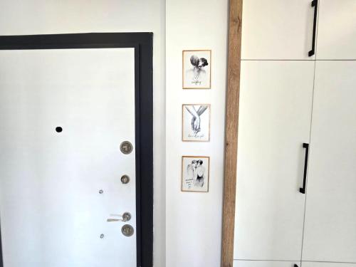 a hallway with white doors and pictures on the wall at odak turizm konutları 2 in Manavgat