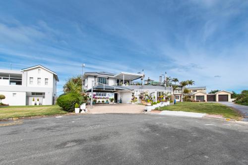 a large white house with a street in front of it at Pearl White Sands in Glentana