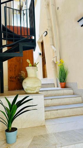 a staircase with a vase and potted plants on it at La carbonaia rooms in Agrigento in Agrigento
