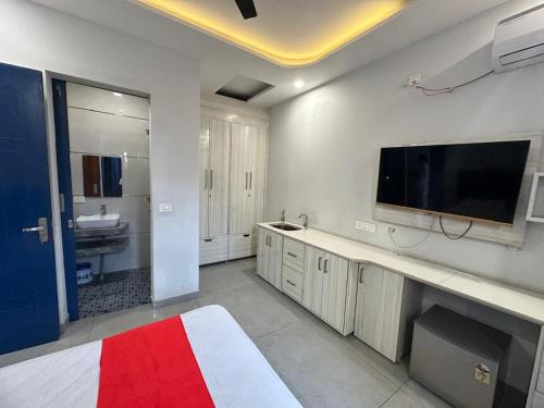 a large white room with a bed and a flat screen tv at SUNNY LUXURIOUS STAY - Comfort with Luxury Feel - Near LPU & Phagwara in Phagwāra