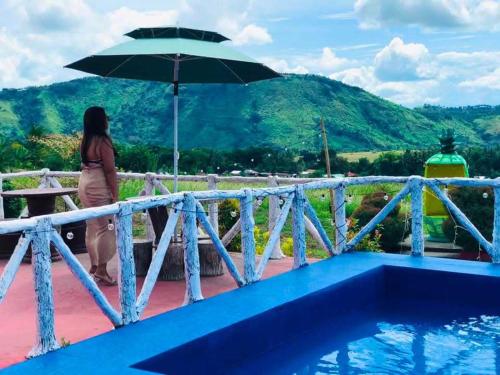 a woman standing on a bridge with an umbrella at Dewpod in Polomolok