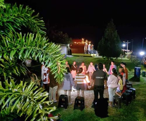 a group of people standing around in a park at night at Dewpod in Polomolok