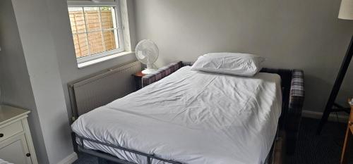 a bedroom with a bed with a fan and a window at Cockhaven Arms in Bishopsteignton