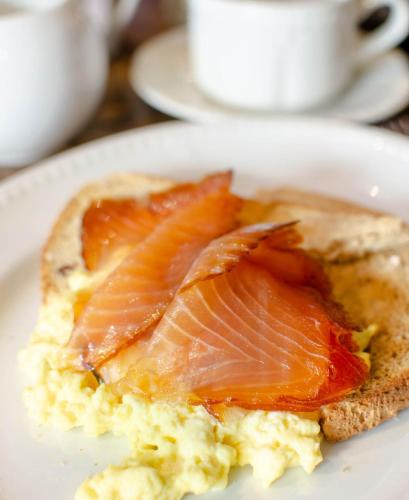 a white plate with a piece of bread with fish on it at Cockhaven Arms in Bishopsteignton