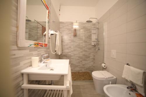 a white bathroom with a sink and a toilet at Hotel Albatros in Torre Vado