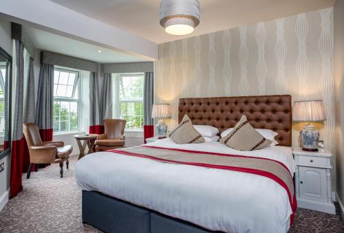 a hotel room with a large bed and chairs at Cockhaven Arms in Bishopsteignton