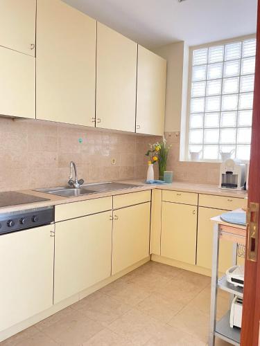 a kitchen with white cabinets and a sink at Varandas do Pinhal in Fão