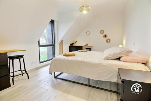 ein Schlafzimmer mit einem großen Bett in einem Zimmer in der Unterkunft Les maisons de l'if - l'escapade in Pluméliau