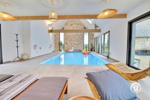 einen Pool in einem Wohnzimmer mit 2 Stühlen in der Unterkunft Les maisons de l'if - l'escapade in Pluméliau