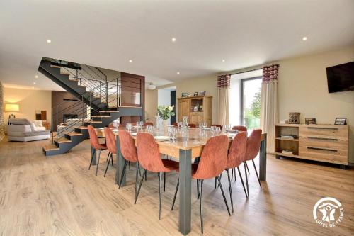 a dining room with a table and chairs and a staircase at Gite de branfere in La Gacilly