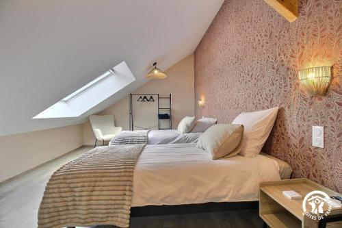 a bedroom with a large bed in a attic at Gite de branfere in La Gacilly