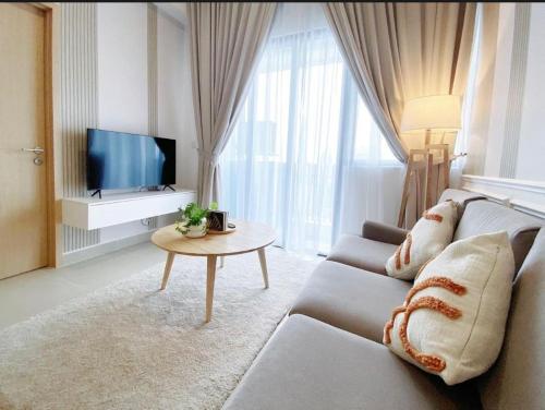 a living room with a couch and a tv at Luxe by KLCC in Gua Sai