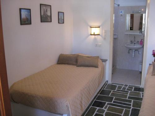 a small bedroom with a bed and a sink at Pension Irini-Vicky in Ios Chora
