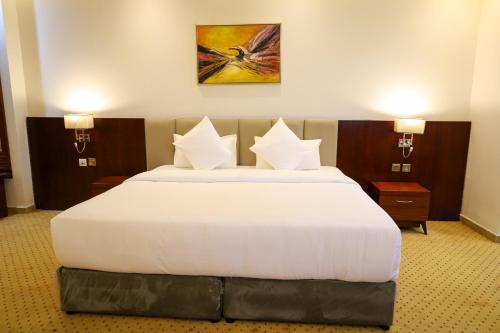 a bedroom with a large white bed with two lamps at Best Day Hotel and Resorts المحمدية in Jeddah