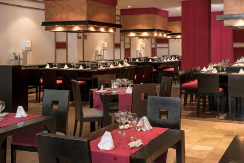 a restaurant with tables and chairs with wine glasses at Grand Sunset Princess - All Inclusive in Playa del Carmen