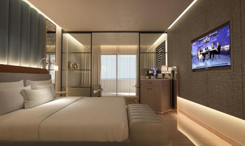 a bedroom with a bed and a tv on a wall at Grand Sunset Princess - All Inclusive in Playa del Carmen