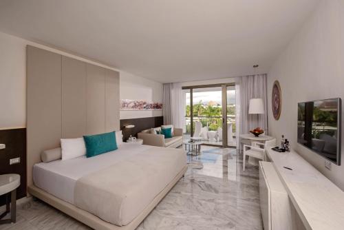 Platinum Yucatan Princess Adults Only - All Inclusive في بلايا ديل كارمن: غرفة نوم بها سرير كبير وغرفة معيشة
