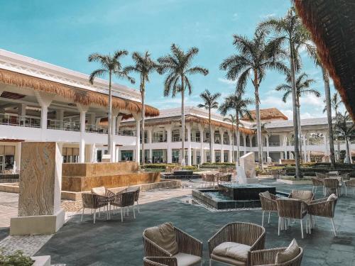 a resort with a fountain and chairs and palm trees at Grand Riviera Princess - All Inclusive in Playa del Carmen
