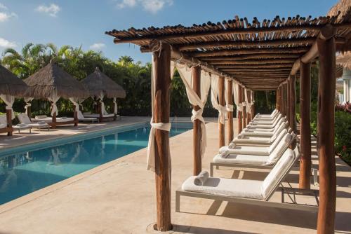 a row of chaise lounges next to a pool at a resort at Grand Riviera Princess - All Inclusive in Playa del Carmen
