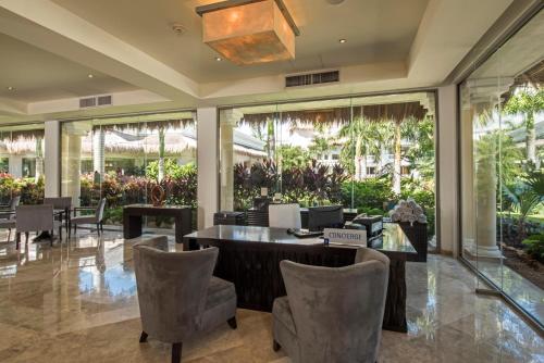a lobby with a table and chairs and windows at Grand Riviera Princess - All Inclusive in Playa del Carmen