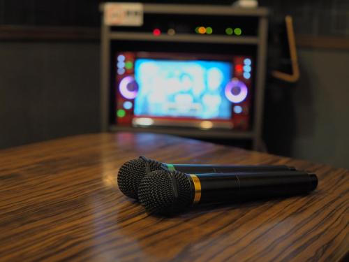 a microphone sitting on top of a wooden table at BE FREE HOTELS甲府は2025年8月にカップル専用のホテルをフルリノベーションした まったく新しいスタイルのホテルです様々なご利用者様の自由な過ごし方を提供するホテルとしてBE FREE HOTELsと名付けました in Showa